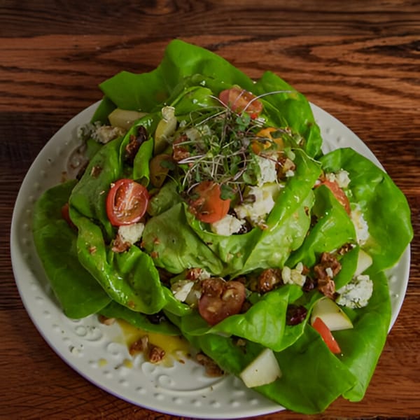 A fresh Maldon’s Brasserie salad with lettuce, tomatoes, cheese, nuts, and microgreens.